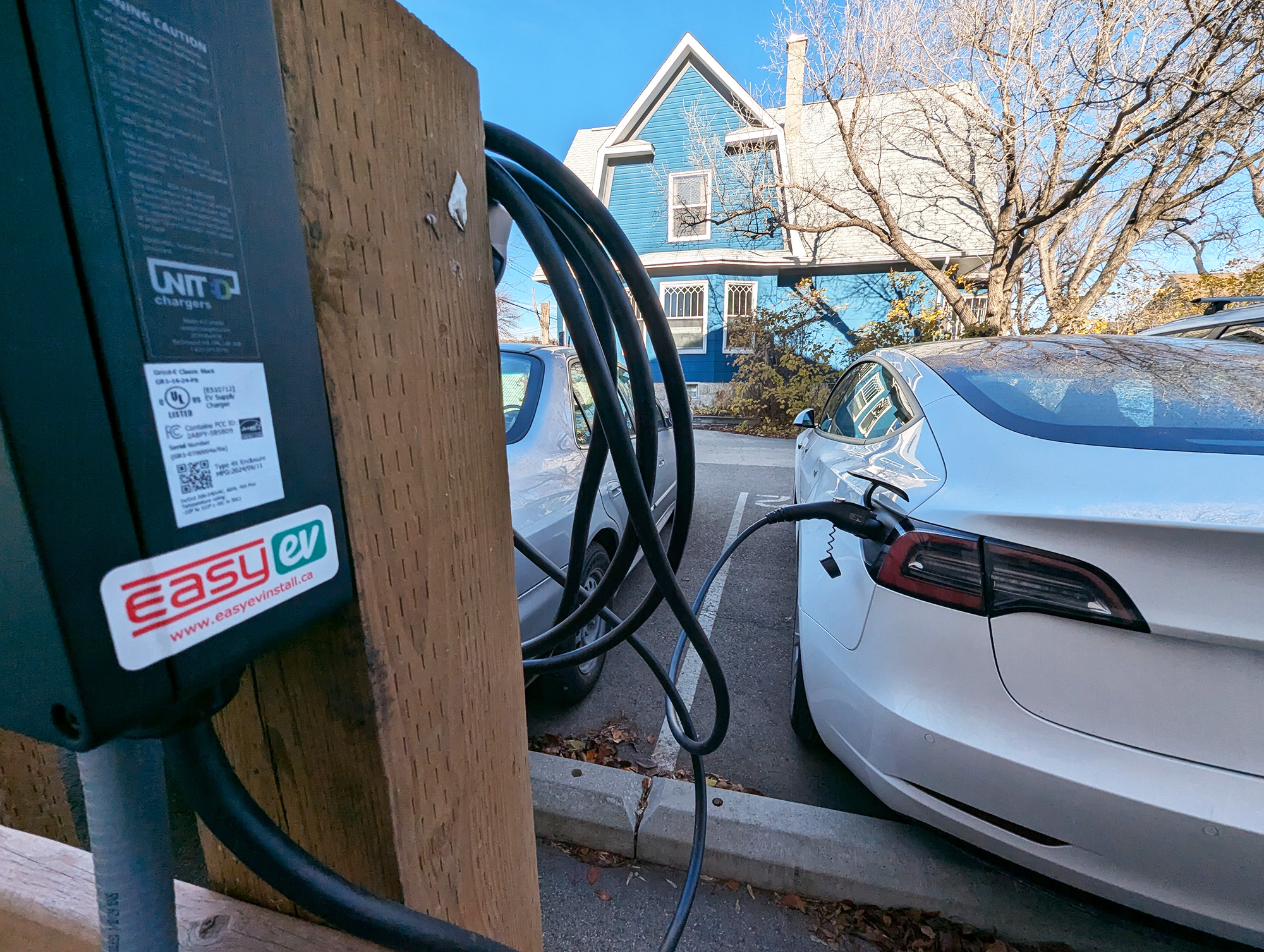Close up of EV charger installation for PegCity Co-op a white car is plugged in.